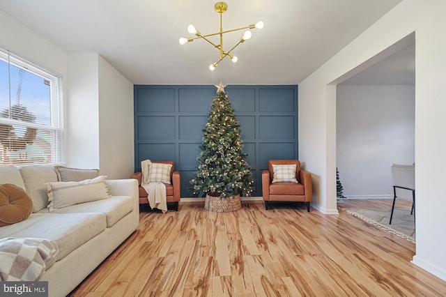 sitting room featuring light wood-type flooring and a notable chandelier