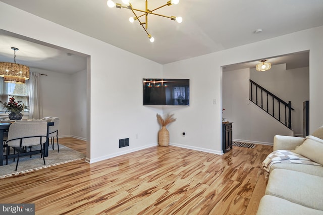 living room featuring a chandelier and wood-type flooring