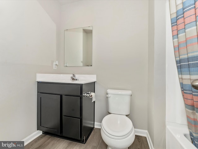 full bathroom featuring hardwood / wood-style flooring, vanity, toilet, and shower / bath combo with shower curtain