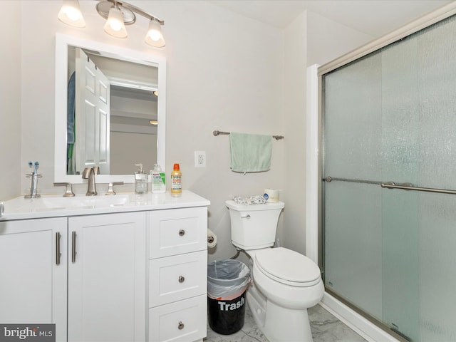 bathroom with vanity, toilet, and a shower with door