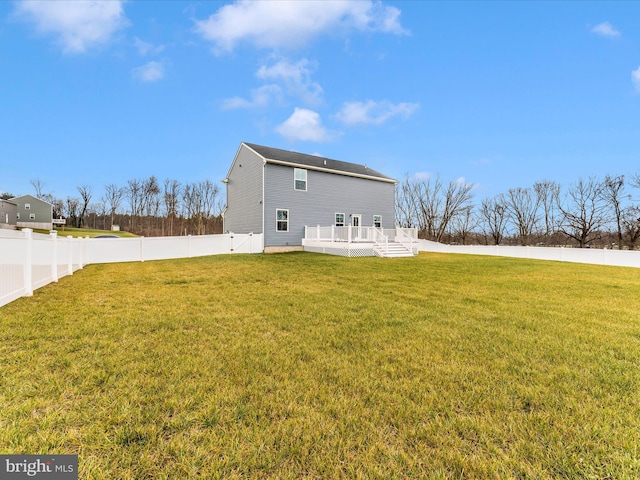 rear view of property with a yard and a wooden deck