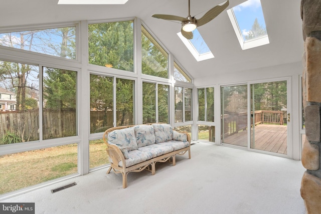 sunroom featuring lofted ceiling with skylight, visible vents, and a ceiling fan