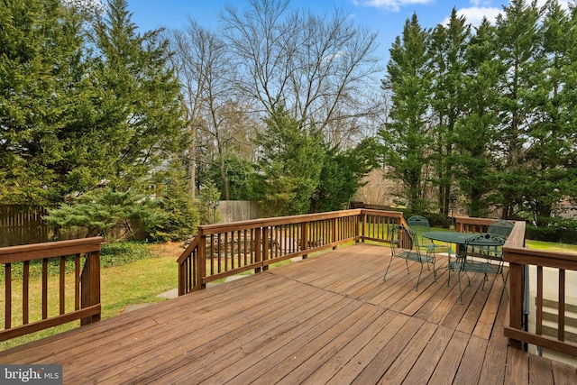 deck featuring a yard, fence, and outdoor dining space