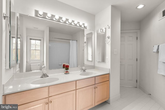 bathroom featuring recessed lighting, a sink, baseboards, and double vanity