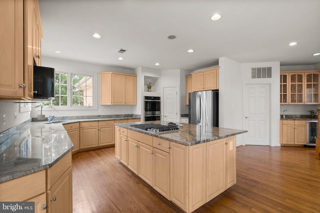 kitchen with visible vents, appliances with stainless steel finishes, wood finished floors, and light brown cabinetry