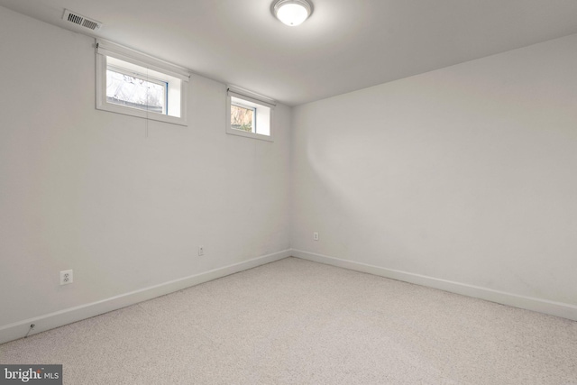 empty room featuring carpet floors, visible vents, and baseboards