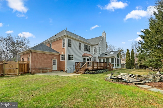 back of house featuring a fenced backyard, a chimney, a gate, a patio area, and brick siding