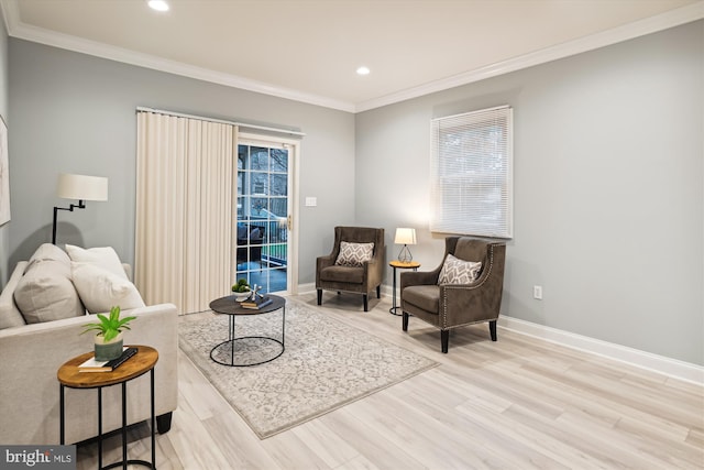 sitting room with crown molding and light hardwood / wood-style flooring