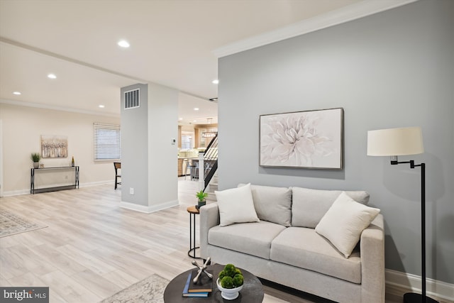 living room featuring light wood-type flooring and crown molding