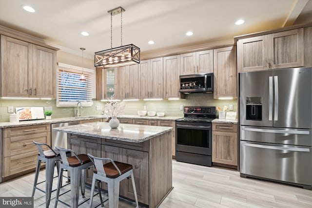 kitchen with pendant lighting, a breakfast bar, appliances with stainless steel finishes, a kitchen island, and light stone counters