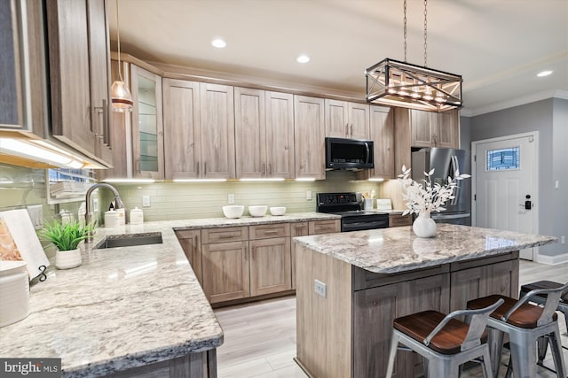 kitchen with a breakfast bar area, light stone counters, sink, and stainless steel appliances