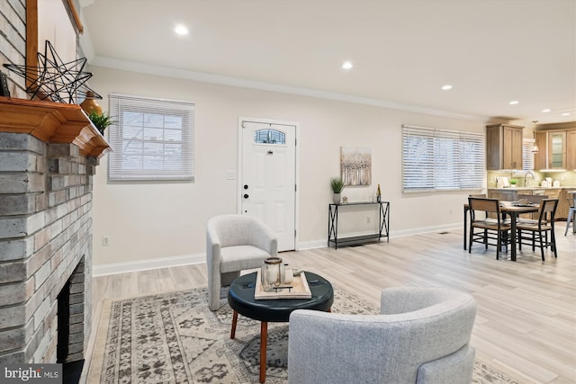 living room featuring plenty of natural light, ornamental molding, and light hardwood / wood-style flooring