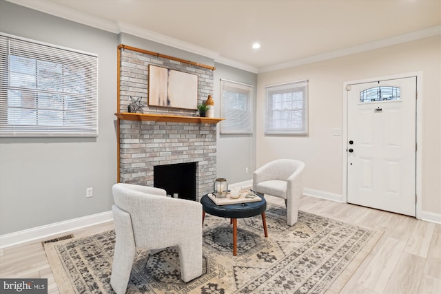 living room with a fireplace, light hardwood / wood-style flooring, and ornamental molding