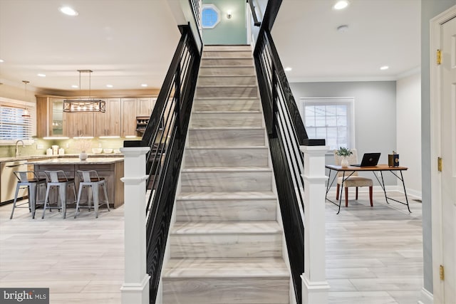 stairs with hardwood / wood-style floors, a healthy amount of sunlight, and sink