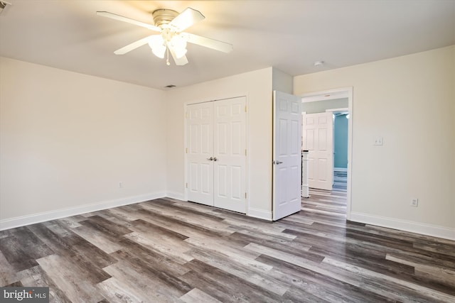 unfurnished bedroom featuring dark hardwood / wood-style flooring, a closet, and ceiling fan