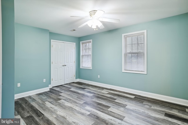 unfurnished bedroom with ceiling fan and dark hardwood / wood-style floors