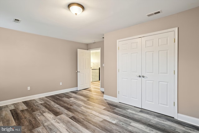 unfurnished bedroom with hardwood / wood-style flooring and a closet