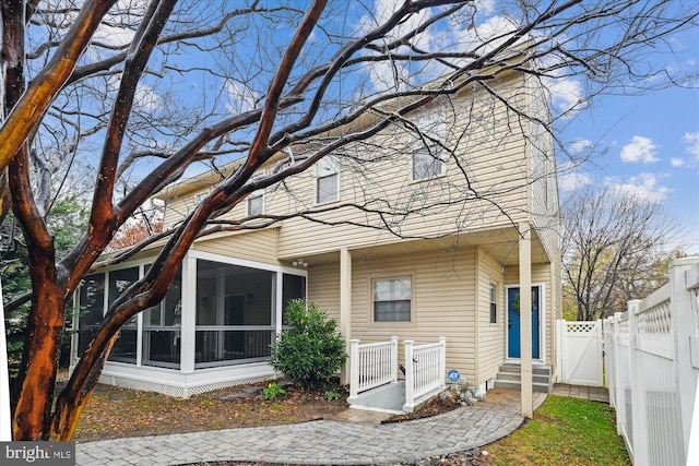 rear view of property featuring a sunroom