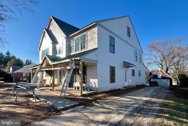 view of front facade featuring covered porch, an outdoor structure, and a garage