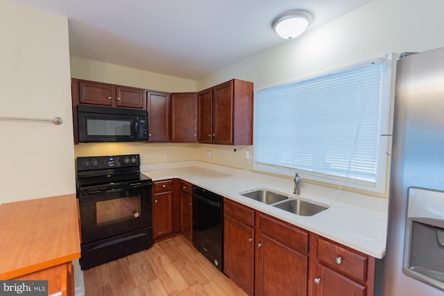 kitchen with light hardwood / wood-style flooring, black appliances, and sink