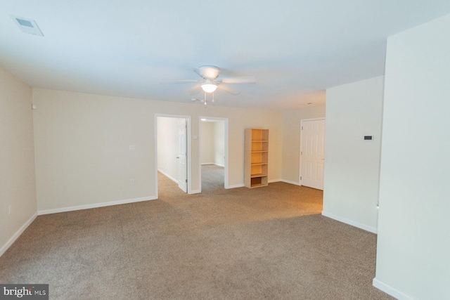 empty room featuring ceiling fan and light carpet