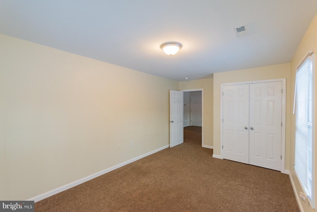 unfurnished bedroom featuring carpet floors and a closet