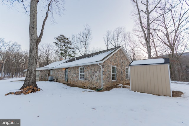 view of snowy exterior with central AC