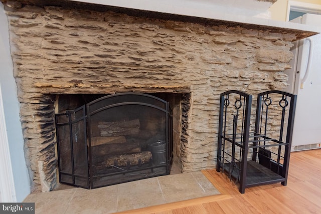 details featuring a tile fireplace and hardwood / wood-style flooring