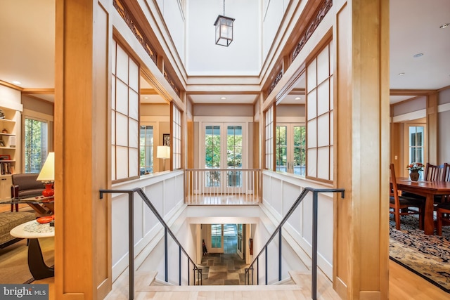 stairway with a wealth of natural light and light hardwood / wood-style flooring