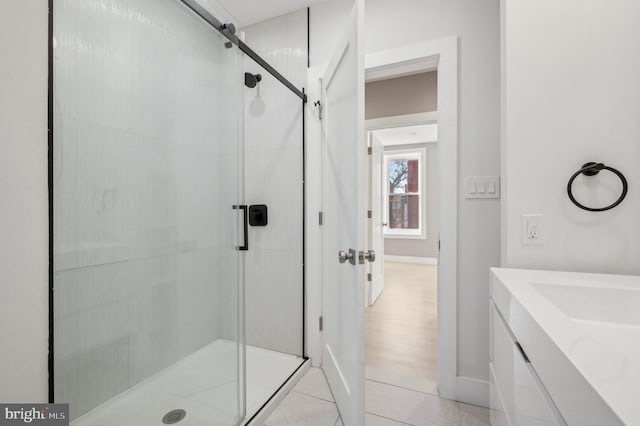 bathroom with tile patterned flooring, vanity, and a shower with door