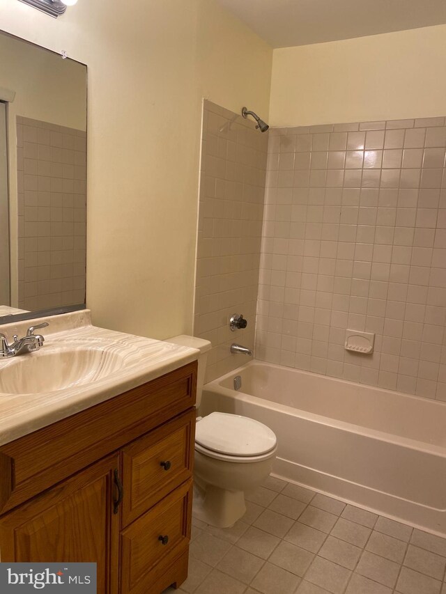 full bathroom with tile patterned floors, tiled shower / bath combo, toilet, and vanity