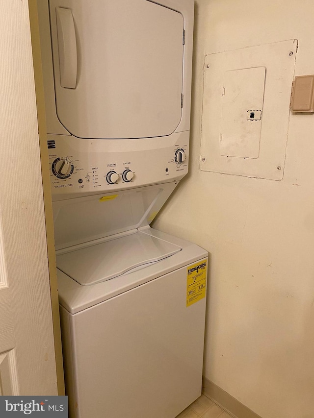 washroom with stacked washer and dryer and electric panel