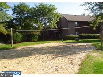 view of home's community with volleyball court and a lawn