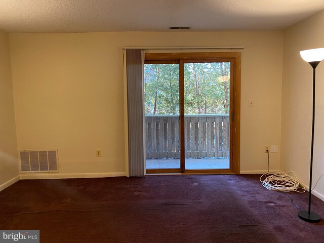 carpeted empty room with a textured ceiling