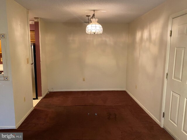 unfurnished dining area featuring a textured ceiling