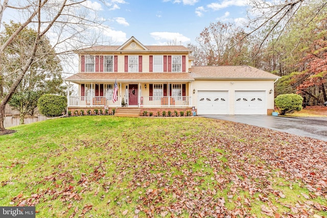 view of front of property featuring a porch, a garage, and a front yard