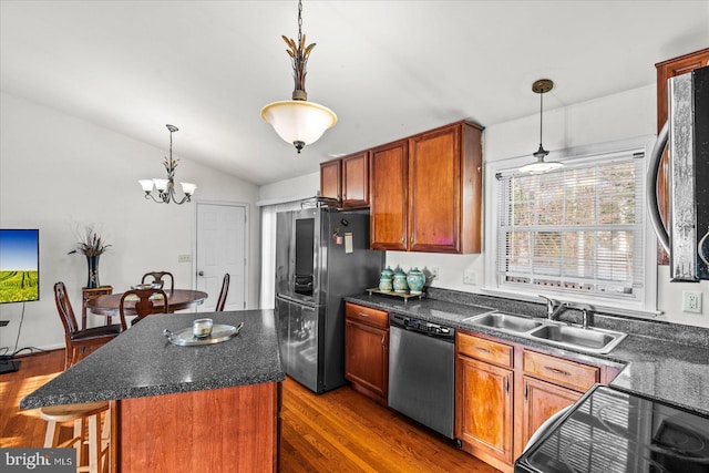 kitchen with stainless steel appliances, dark wood-type flooring, sink, decorative light fixtures, and a center island