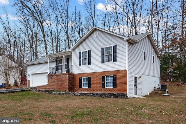 view of front of property with central AC, a front yard, and a garage