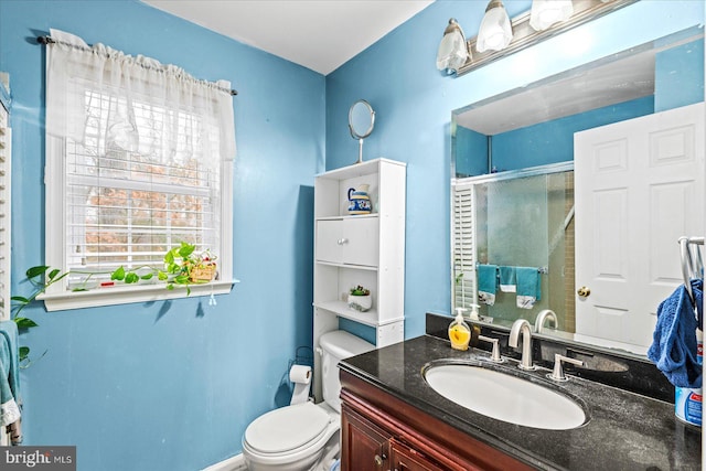 bathroom featuring vanity, an enclosed shower, and toilet