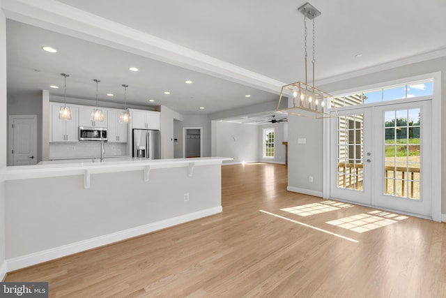 kitchen featuring appliances with stainless steel finishes, white cabinetry, french doors, and a healthy amount of sunlight