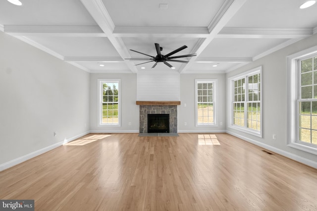 unfurnished living room featuring beam ceiling, a fireplace, and light hardwood / wood-style flooring