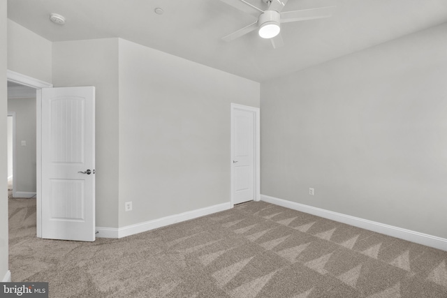 carpeted spare room with ceiling fan