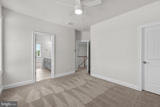 unfurnished bedroom with connected bathroom, ceiling fan, and light colored carpet