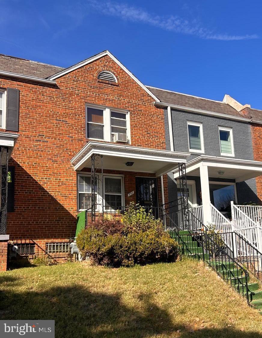 multi unit property featuring a porch, a front yard, and cooling unit