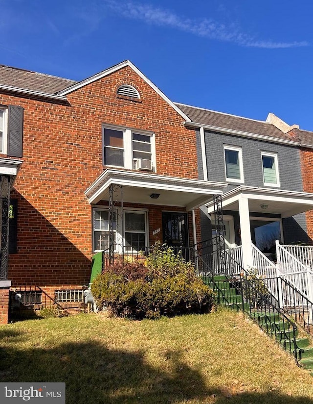 multi unit property featuring a porch, a front yard, and cooling unit