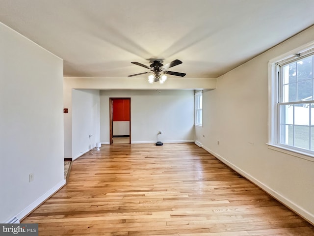 empty room with ceiling fan, a healthy amount of sunlight, and light hardwood / wood-style floors