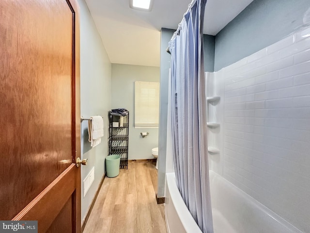 bathroom with toilet, shower / tub combo with curtain, and hardwood / wood-style flooring