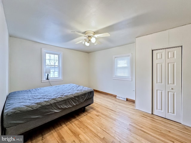 bedroom featuring a closet, light hardwood / wood-style flooring, and ceiling fan