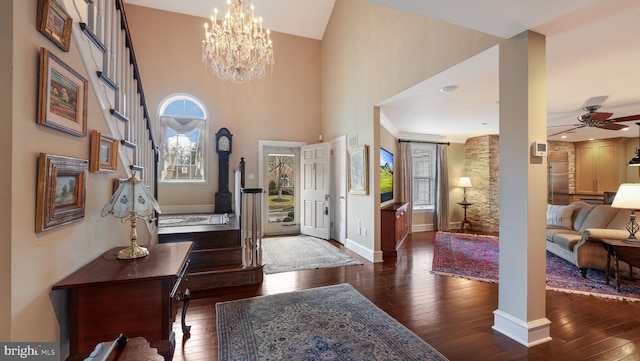 entryway with plenty of natural light, dark wood-type flooring, and ceiling fan with notable chandelier