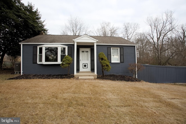 view of front of house featuring central AC unit and a front lawn